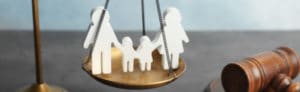 wood carvings of family on a scale next to a gavel