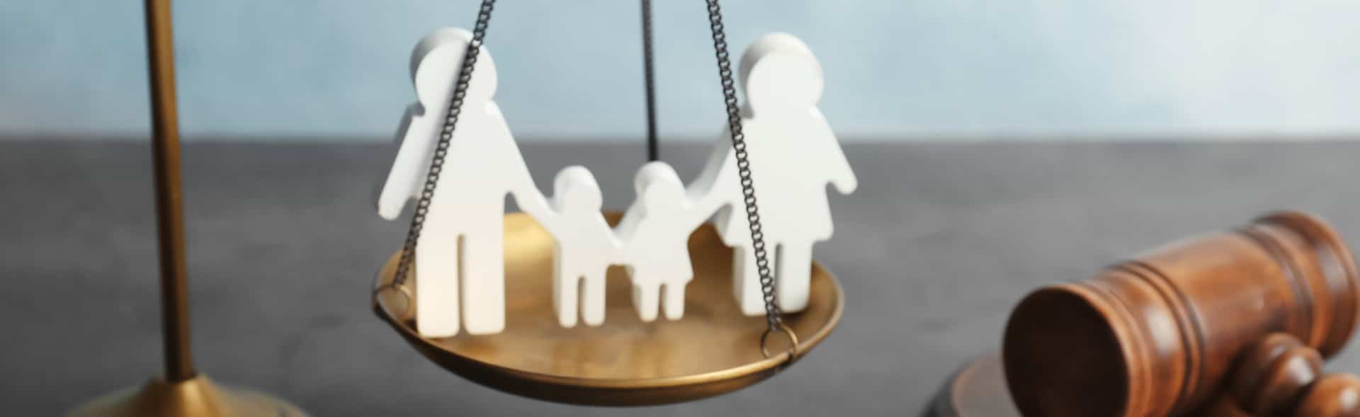 wood carvings of family on a scale next to a gavel