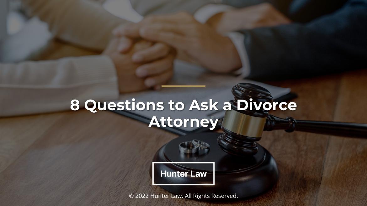 Featured: lawyer and client's hands on desk discussing divorce - 8 Questions to Ask a Divorce Attorney (title)