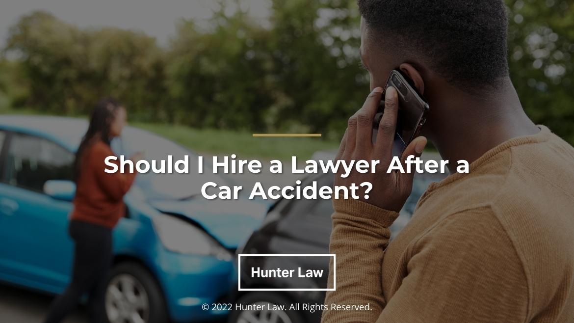 Featured: Male talking on mobile phone at scene of accident - Should I Hire a Lawyer After a Car Accident?