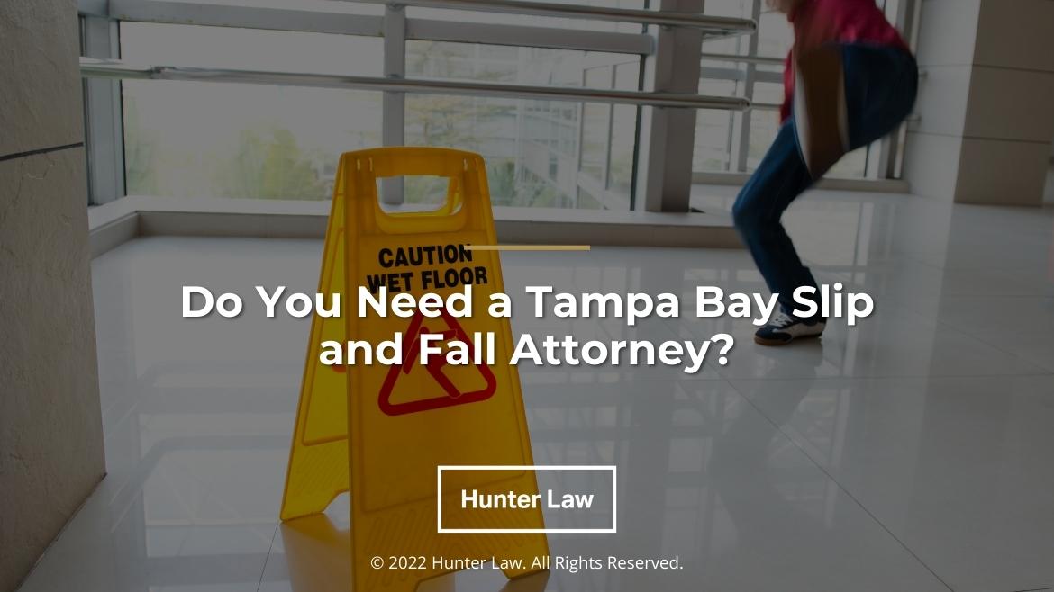Featured: Man slipping on a wet floor next to a Wet Floor sign - Do You Need a Tampa Bay Slip and Fall Attorney?