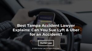 Featured: rideshare driver in car using app- Best Tampa Accident Lawyer Explains: Can You Sue Lyft & Uber for an accident?