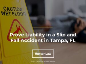 Person lying on floor near "Caution Wet Floor: sign- Prove Liability in a Slip and Fall Accident in Tampa, FL.