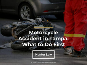 Damaged motorcycle lies in street with emergency worker. Article title.